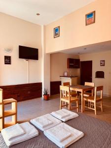 Una sala de estar con una mesa y sillas y un televisor. en Quenti apart salta, en Salta