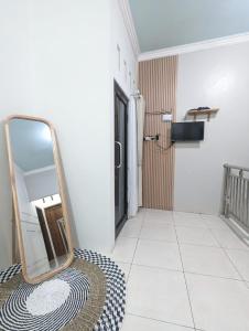 einen Spiegel, der auf einem Boden in einem Zimmer sitzt in der Unterkunft Homestay Lingga Yoni DIENG in Banjarnegara
