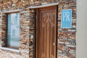 a wooden door on a brick building with a parking sign at Casa Veiga in Valdoviño