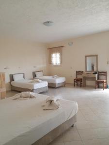 Habitación grande con 2 camas y mesa. en Barbara II en Agia Marina Aegina