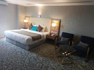 a hotel room with a bed and two chairs at فوربوينتس الشهباء Four points Alshahba in Jeddah