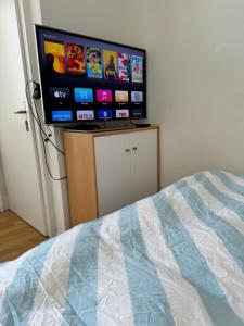 a flat screen tv sitting on a stand in a bedroom at City Center Studio-balcony at town hall in Basel