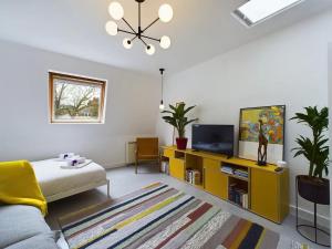 a living room with a couch and a tv at Pass the Keys Stylish and Modern 2Bed 2Bath Hackney Apartment in London