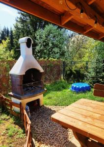 patio trasero con horno al aire libre y mesa de picnic en Domki w Dolinie Radomki, 