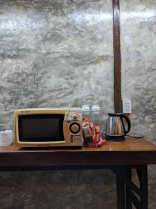 a microwave sitting on top of a table at STAY Hostel & Motorbike Rental - Thakhek in Thakhek