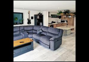 a living room with a blue couch and a kitchen at 3 bed House in Newquay, Cornwall in Newquay