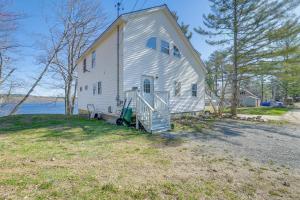 a large white house with a staircase in front of it at Waterfront Hampden Home on Hermon Pond! in Hampden