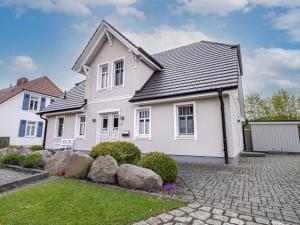 a white house with a black roof at Haus STRANDLUST WF-04 in Wustrow