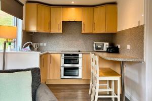 een keuken met houten kasten en een aanrechtblad bij Skye in Oban