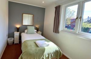 een kleine slaapkamer met een bed en een raam bij Skye in Oban