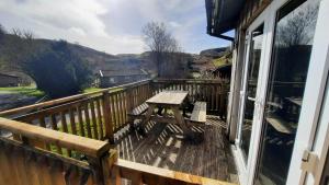 een houten terras met een picknicktafel op een balkon bij Skye in Oban