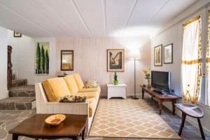 a living room with a couch and a tv at La Veranda - Appartamento con giardino privato in Ghizzano