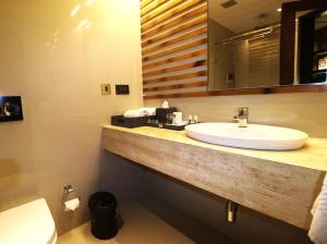 a bathroom with a sink and a mirror and a toilet at Hotel Swosti Premium Bhubaneswar in Bhubaneshwar