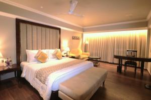a hotel room with a large bed and a desk at Hotel Swosti Premium Bhubaneswar in Bhubaneshwar