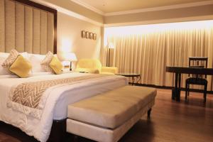 a hotel room with a large bed and a piano at Hotel Swosti Premium Bhubaneswar in Bhubaneshwar