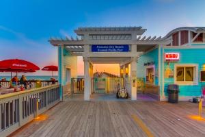 un bâtiment sur une promenade avec l'océan en arrière-plan dans l'établissement Lake Town Wharf, à Panama City Beach