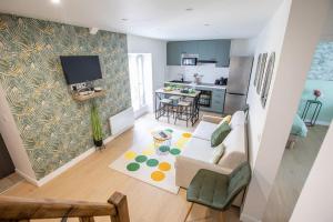 a living room with a couch and a kitchen at Duplex 3 chambres, Aéroport Paris CDG, Parc des Expositions, Parc Asterix, in Mitry-Mory
