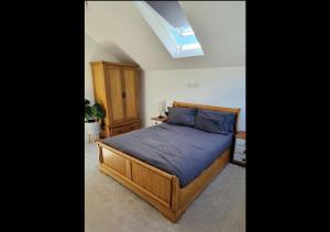 a bedroom with a wooden bed and a skylight at 3 bed House in Newquay, Cornwall in Newquay
