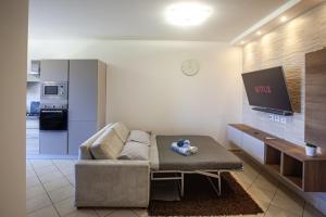 un soggiorno con divano e TV di Casa moderna con vista Etna e mare vicinissima alla spiaggia a Mascali
