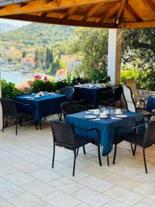 a patio with blue tables and chairs with a view at Boutique Hotel Tomić in Lopud Island
