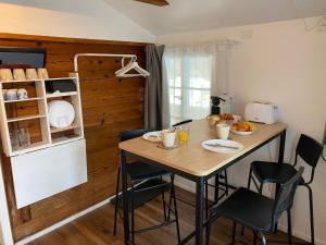 a kitchen with a table with chairs and a refrigerator at Chalet Studio Apartment with Aircon in Interlaken