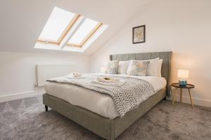 a bedroom with a large bed with a skylight at Beautifully done 5 bed barn conversion in Heswall - Sleeps up to 10 in Heswall