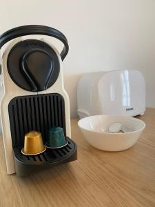 インターラーケンにあるChalet Studio Apartment with Airconの茶碗の横のテーブルに座ったトースター