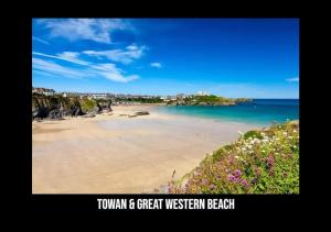 a view of a beach with flowers and the ocean at 3 bed House in Newquay, Cornwall in Newquay