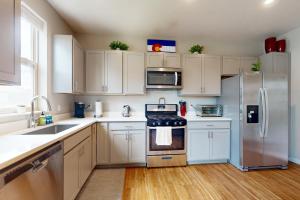 a kitchen with white cabinets and a stainless steel refrigerator at Modern Gem in Gypsum in Eagle