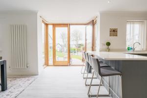 a kitchen with a counter with stools in it at Beautifully done 5 bed barn conversion in Heswall - Sleeps up to 10 in Heswall