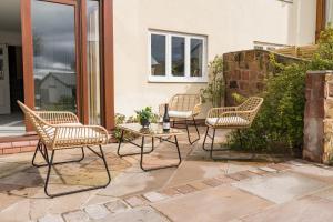 four chairs and a table on a patio at Beautifully done 5 bed barn conversion in Heswall - Sleeps up to 10 in Heswall