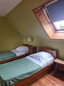 a attic bedroom with two beds and a skylight at Le clos de Tournes in Echinghen