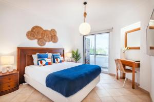 a bedroom with a large bed and a desk at Clube Albufeira: 2BR Prime Holidays Retreat in Albufeira