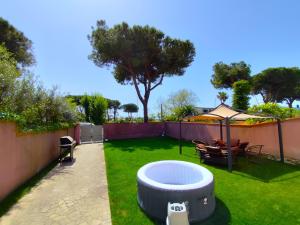 a backyard with a hot tub in the grass at - SeaFront Deluxe Home- [Private Jacuzzi & Garden] in Marina di Carrara