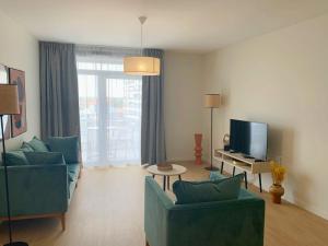 a living room with two blue couches and a television at Résidence Domitys Pèira Ròsa - Toulouse Purpan in Toulouse