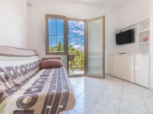 a living room with a couch and a tv and sliding glass doors at Apartment and rooms Kristina in Baška