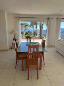 a dining room with a table and chairs and a couch at Casa Antonietta Alata vue imprenable sur la mer in Alata