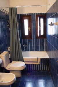 a bathroom with a toilet and a tub and a sink at Turquoise Villa Loutraki in Loutraki