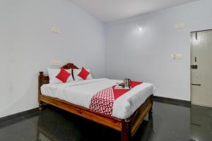 1 dormitorio con 1 cama con almohadas rojas en Flagship Sai International Near Nagasandra Metro Station en Bangalore