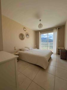 a bedroom with a large bed and a large window at Casa Antonietta Alata vue imprenable sur la mer in Alata