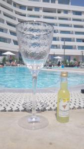 a wine glass and a bottle next to a pool at Sea Side 92 Eilat סיסייד 92 אילת in Eilat