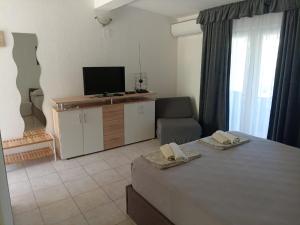 a room with a bed and a tv and a couch at Apartments Šešo in Pag