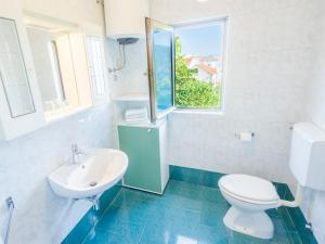 a bathroom with a toilet and a sink and a window at Apartment and rooms Kristina in Baška +22 photos