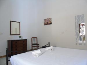 a bedroom with a white bed and a chair at Homiday - Residenza Il Moro in Roseto degli Abruzzi +15 photos