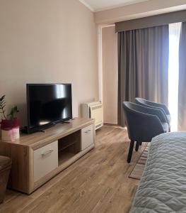 een hotelkamer met een televisie en een bed bij Abazovic Apartments in Ulcinj