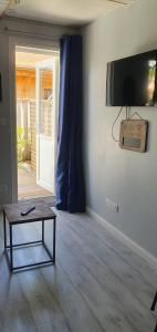 een woonkamer met een tafel en een tv aan de muur bij Le cocooning in Andernos-les-Bains