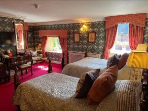 sypialnia z 2 łóżkami i biurkiem oraz pokój w obiekcie Lands of Loyal hotel w mieście Alyth