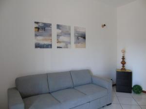 a living room with a couch and a painting on the wall at Homiday - Residenza Il Moro in Roseto degli Abruzzi