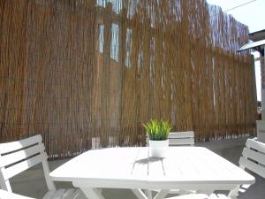 a white table with a potted plant on a fence at Homiday - Residenza Il Moro in Roseto degli Abruzzi