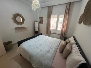 a bedroom with a large bed and a mirror at Chott Meriem avec terrasse in Chott Meriem